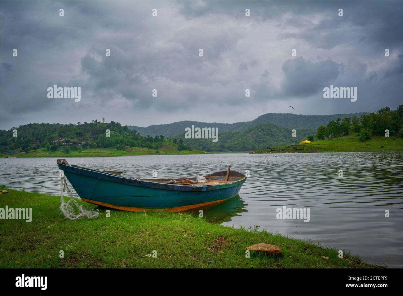 stunning clouds at countryside with green boat and grass with mountain Stock Photo