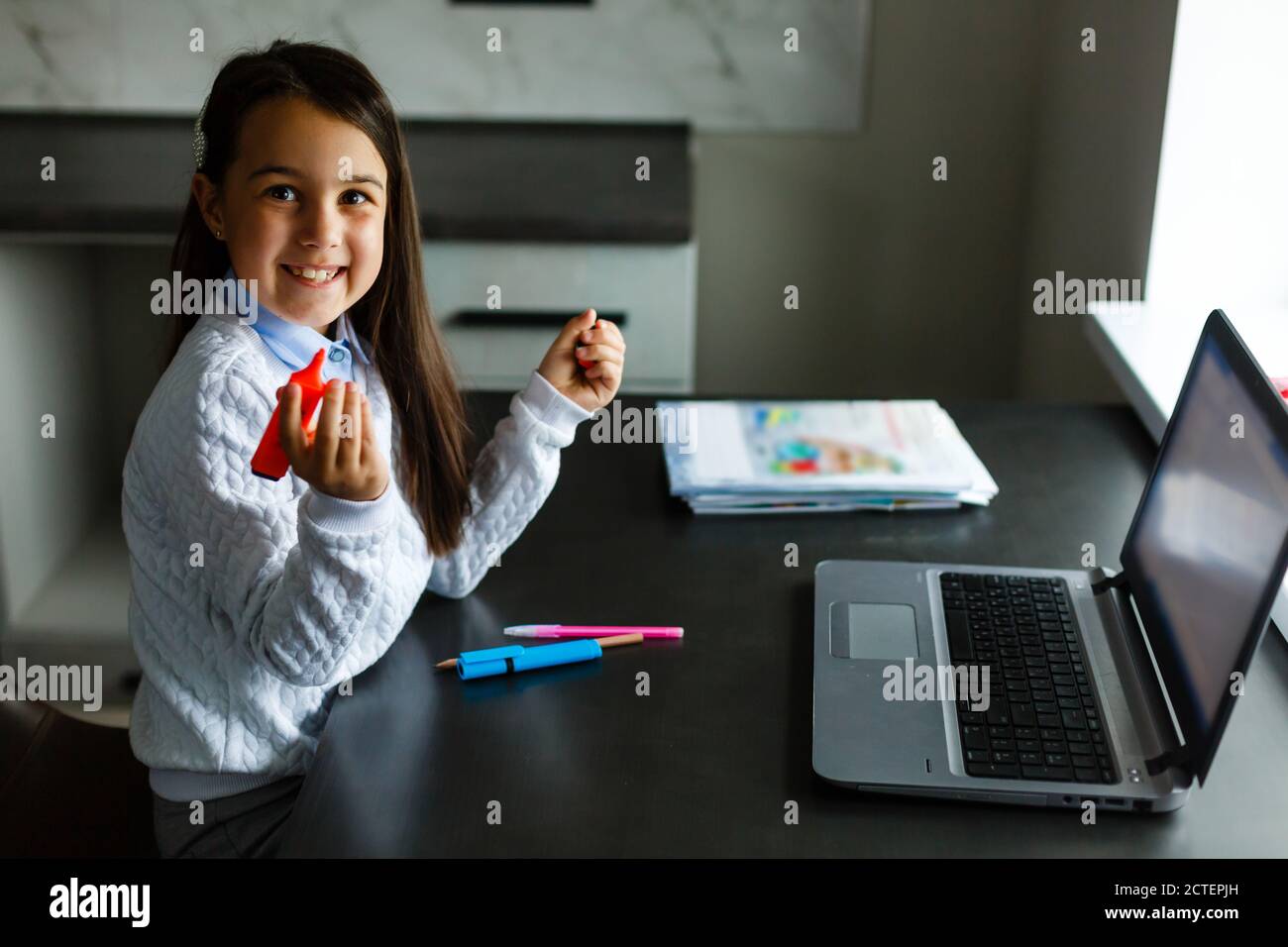 Little girl studying online using her laptop at home Stock Photo - Alamy
