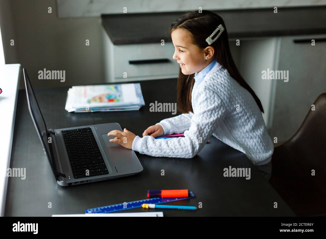 Little girl studying online using her laptop at home Stock Photo - Alamy