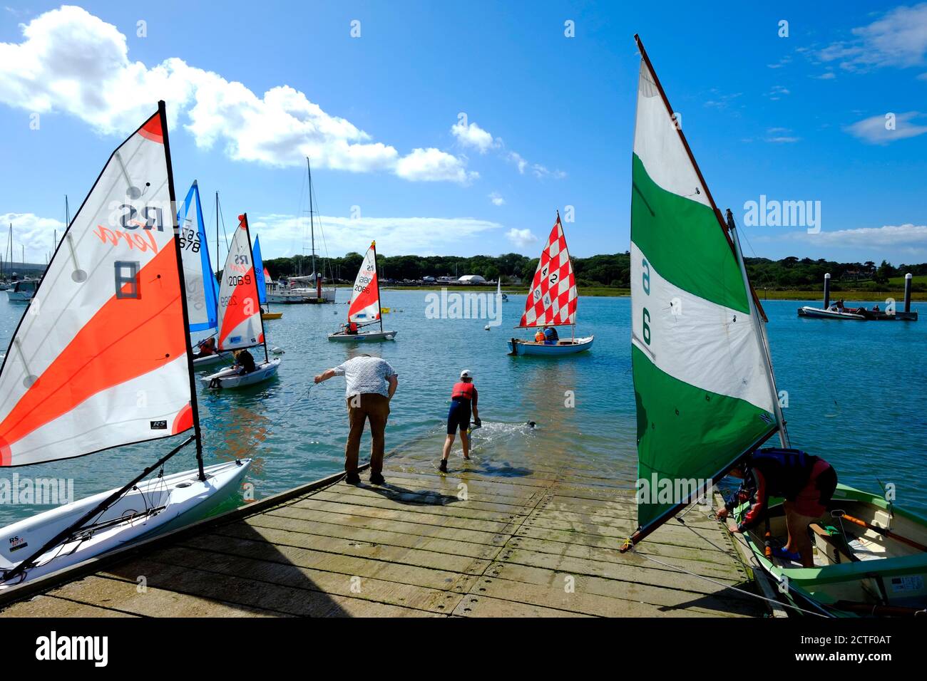 Sailing dinghies with colourful sails up congregating around the