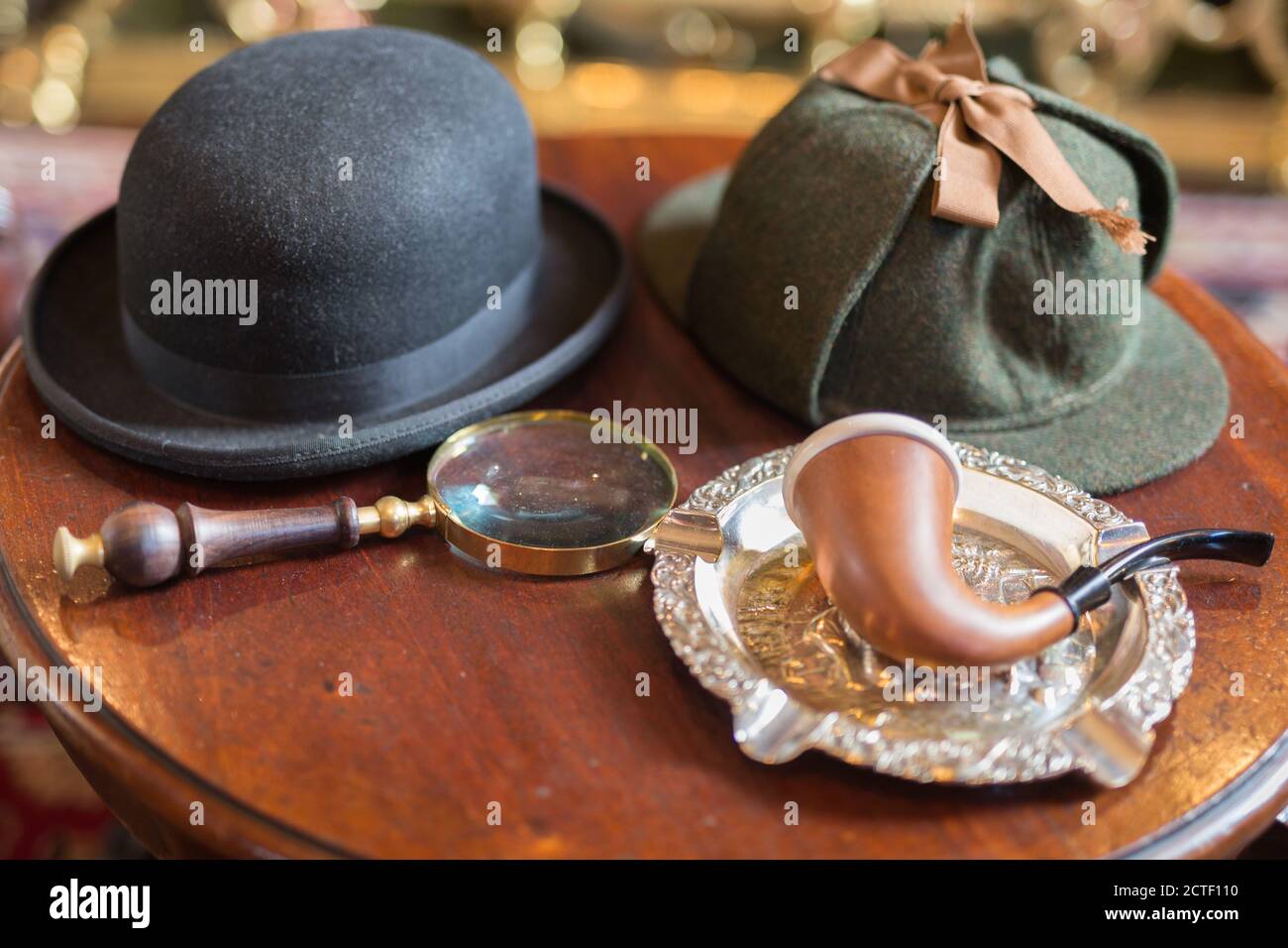 Sherlock Holmes Typical Objects on a Little Wooden Table: Deerstalker, Pipe, Magnifier. Stock Photo