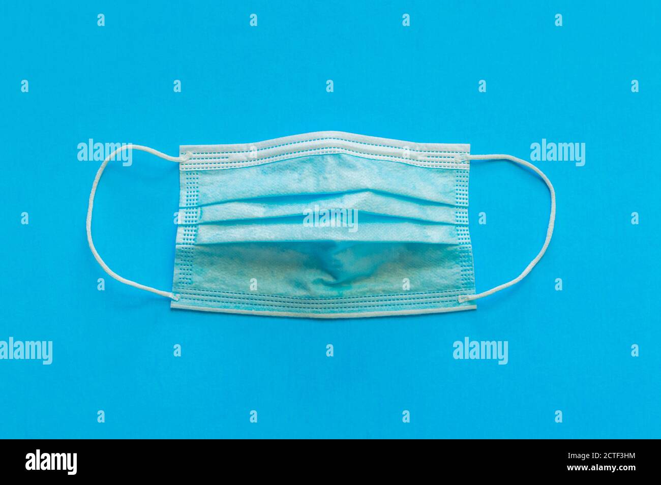 A blue medical face mask is isolated on a blue background Stock Photo