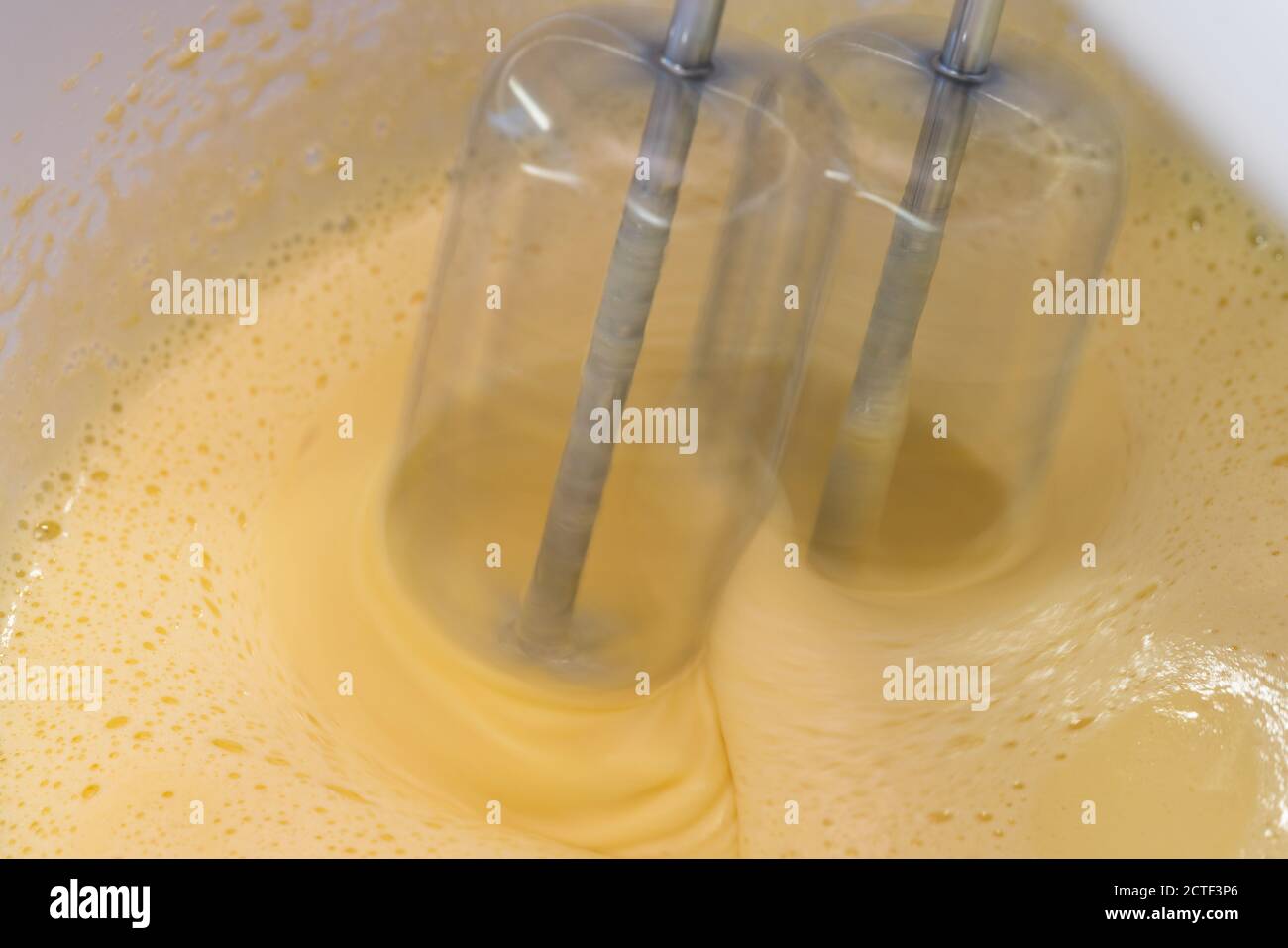 Mixing biscuit dough with an electric mixer. close up process. Cake batter making. Stock Photo