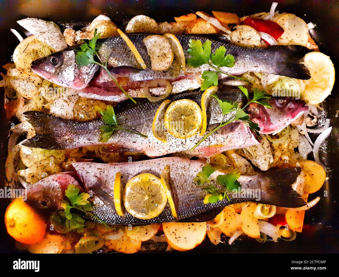 Baked sea bass with potatoes and lemon Stock Photo Alamy