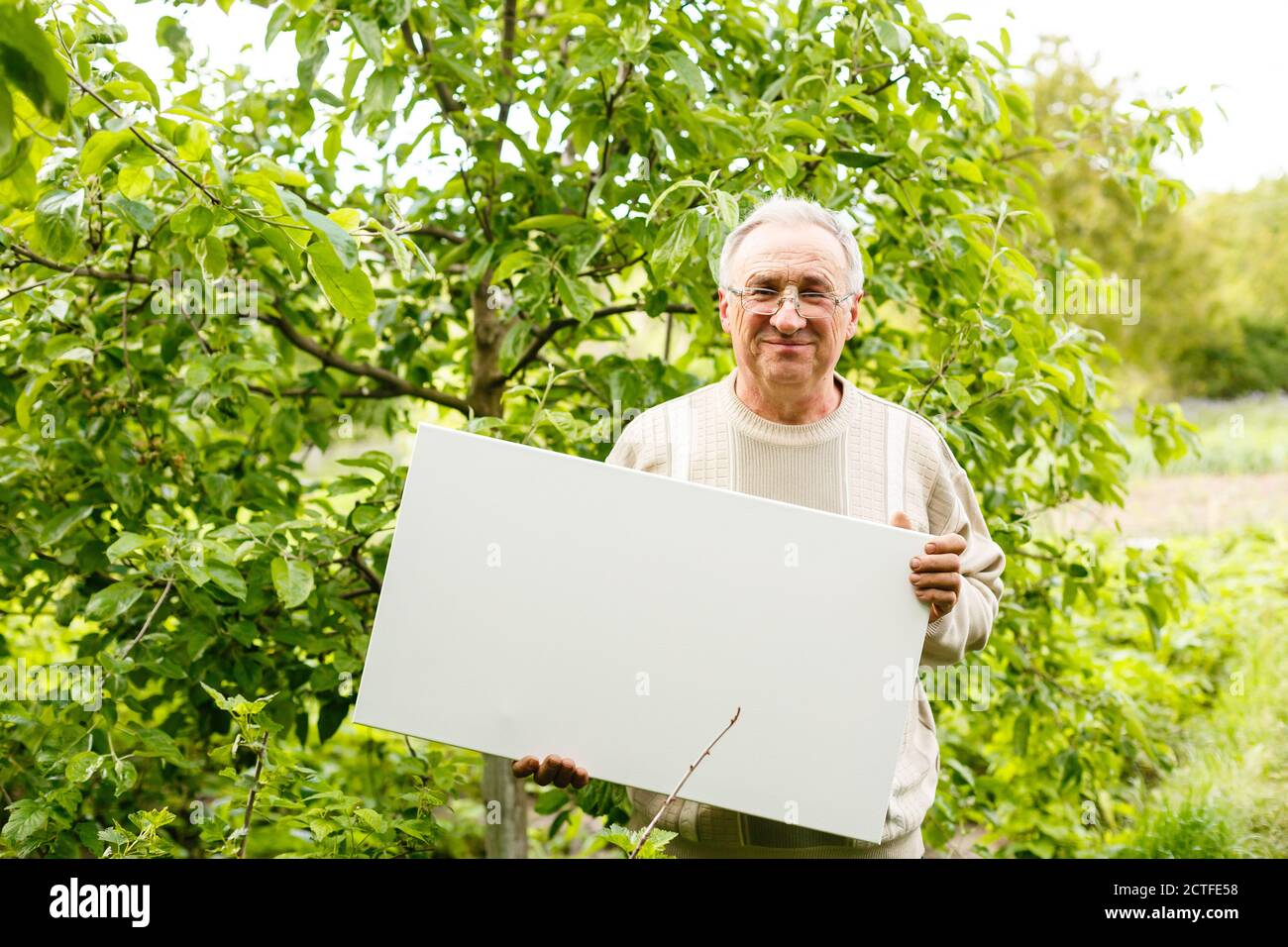 close up of elder man holding blank canvas. room for text. Stock Photo