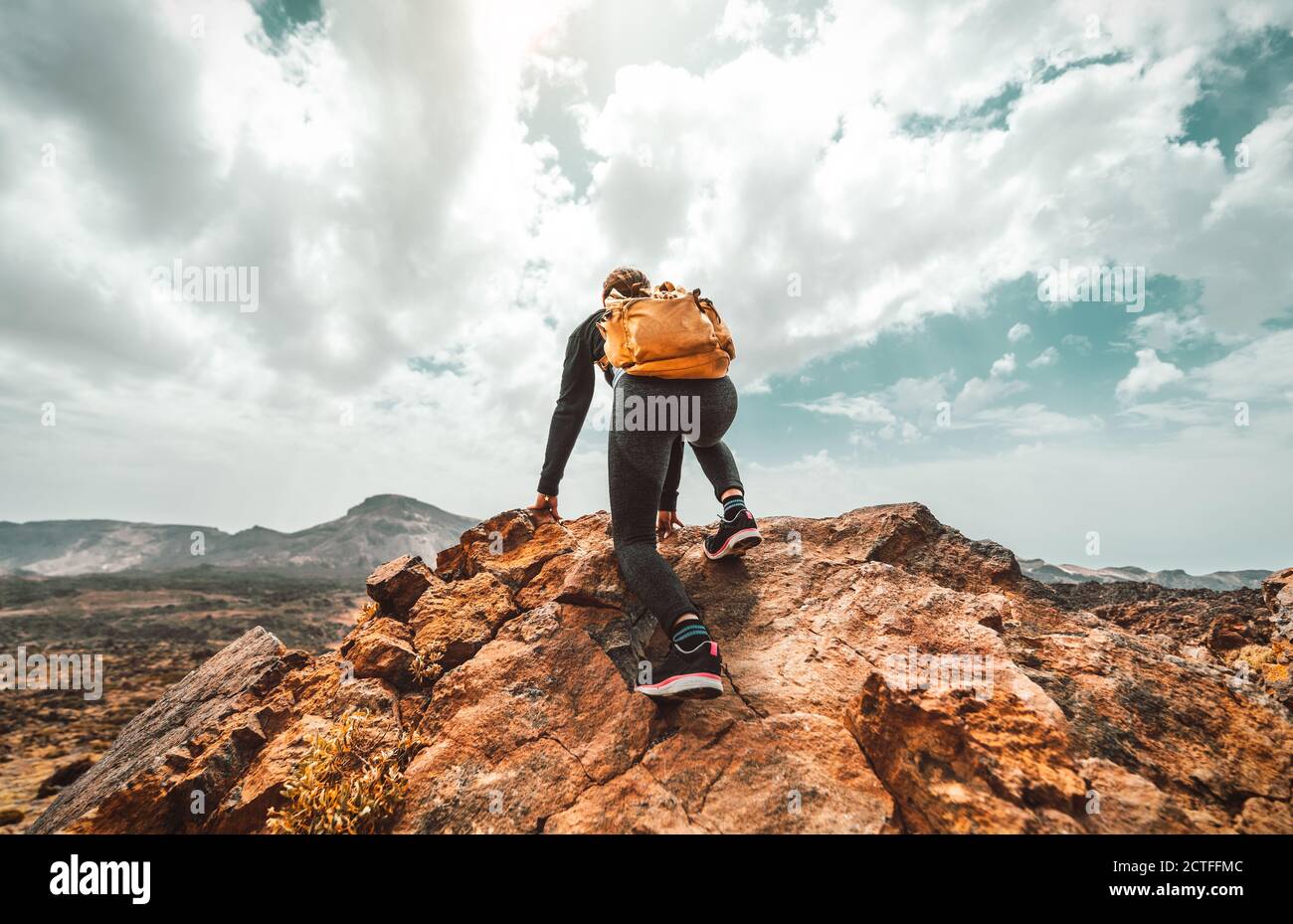Successful hiker woman with backpack on the top of the mountain looking ...