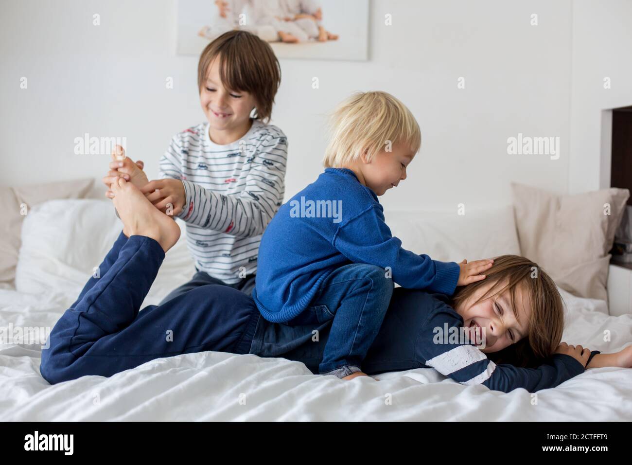 Children, brothers, playing at home, tickling feet laughing and smiling Stock Photo