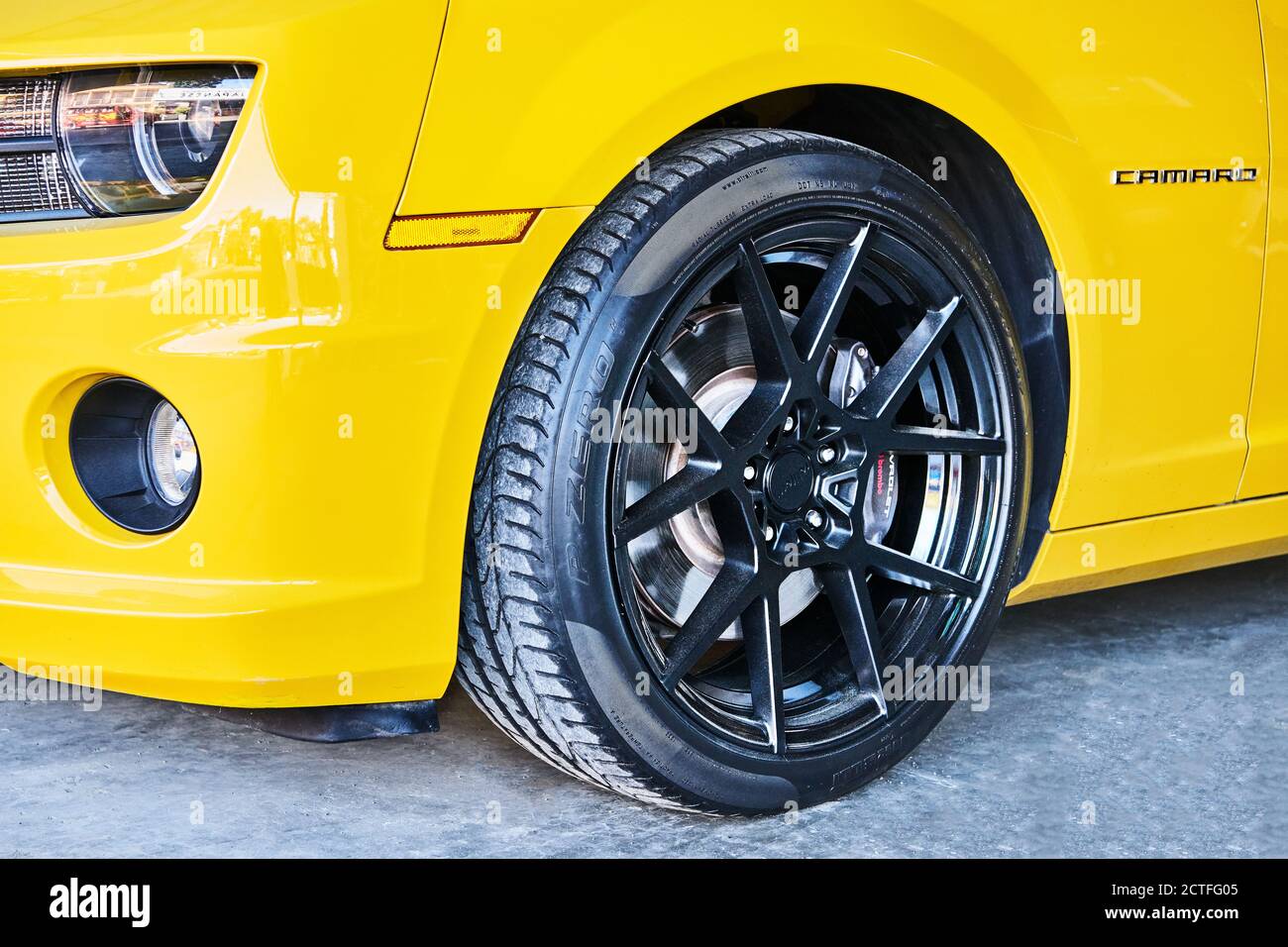 Isolated side view of a wheel and headlights of a yellow Chevrolet Camaro sports car parking along the road in Iloilo city, Philippines, Asia Stock Photo