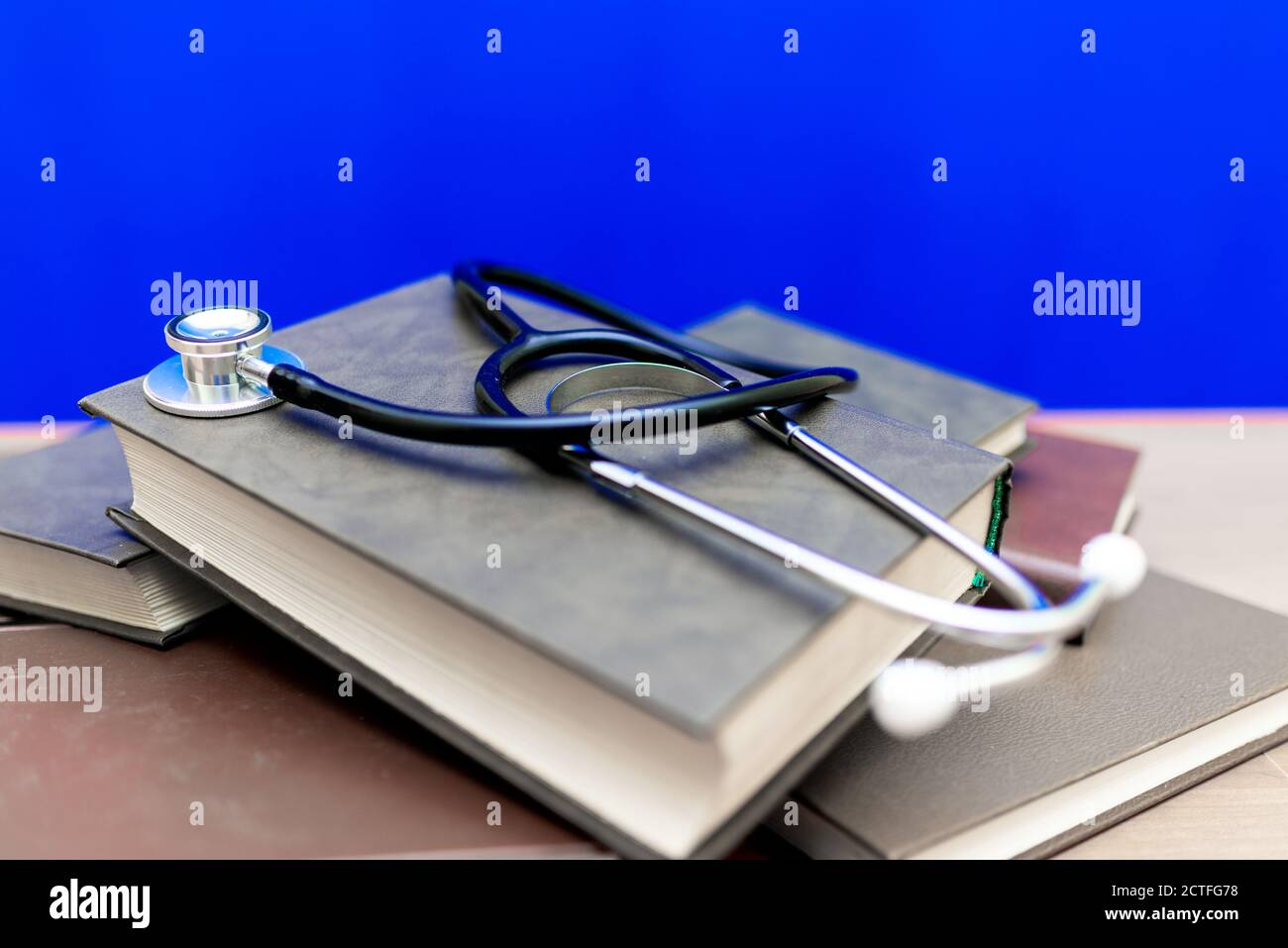 Stethoscope with stack of books on table or blue trendy background ...