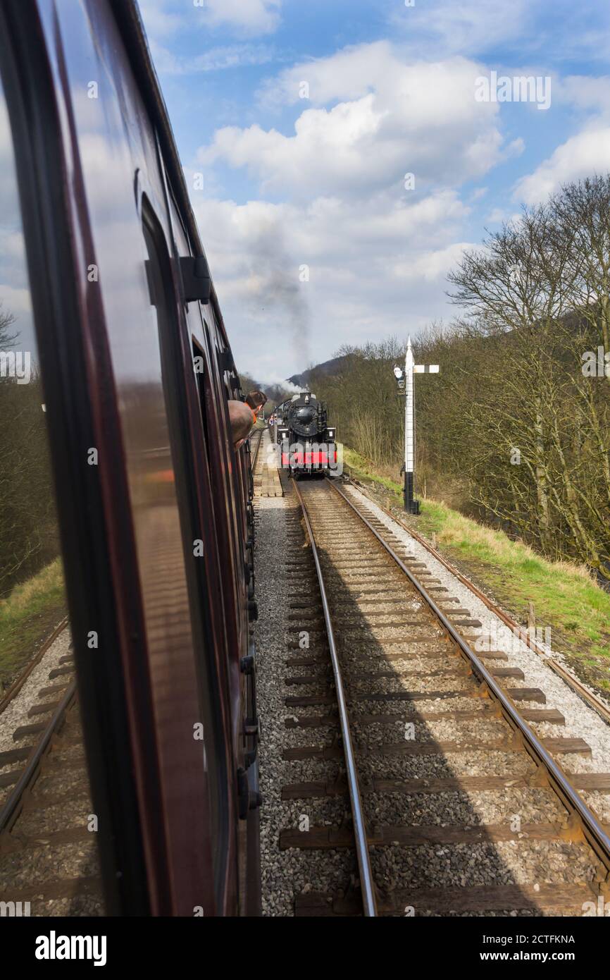 Former United States of America Transportation Corp S160, 5820 steam train approaches a Keighley-bound train at Damems passing loop on the KWVR. Stock Photo