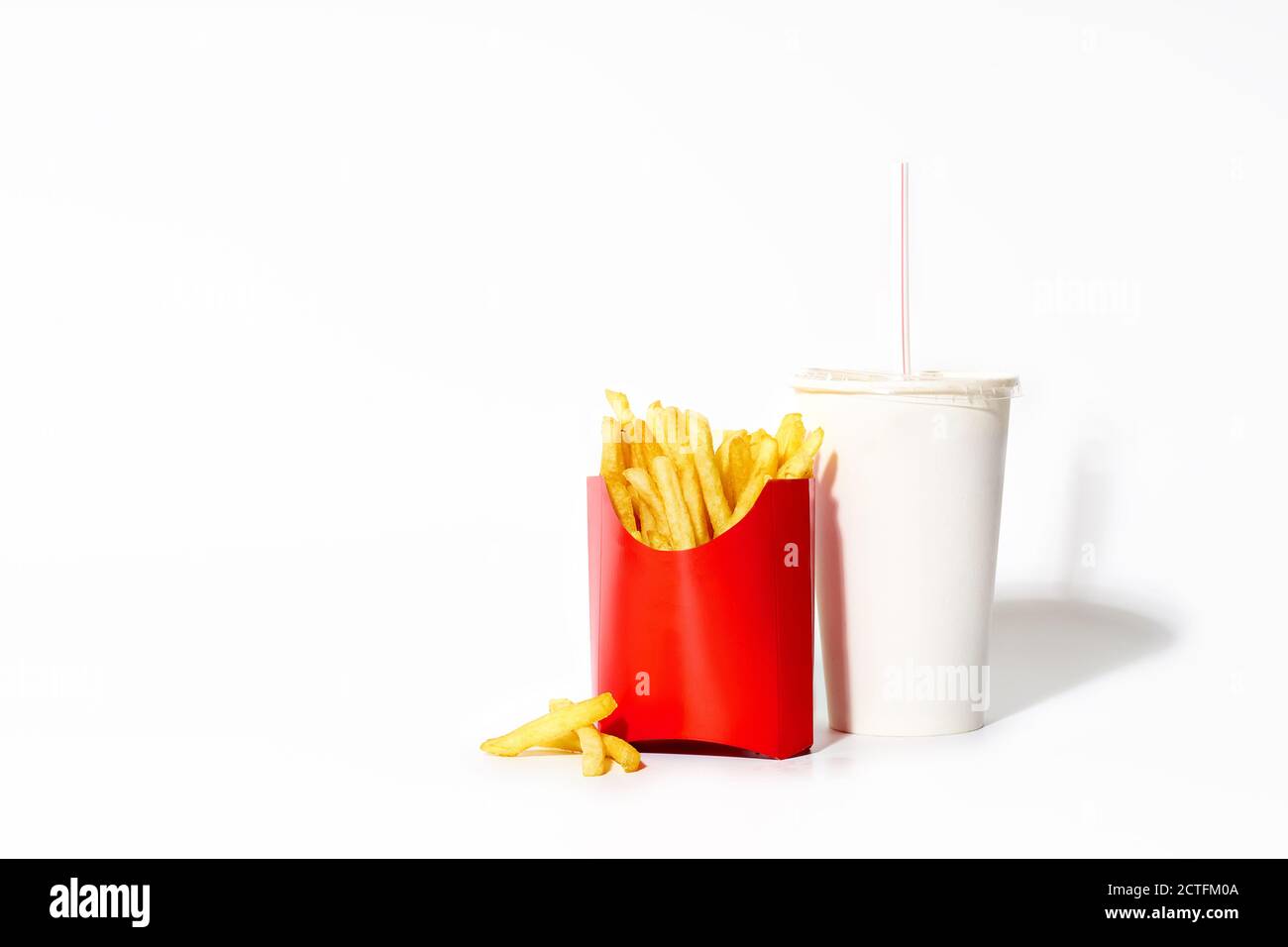 Fried potatoes isolated on white background with a drink in a plastic cup. French fries with copy space. Junk food Stock Photo
