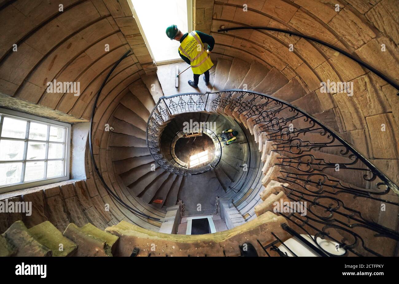 Workers on the east spiral staircase which sits one end of the Central Hall at the National Trust's Seaton Delaval Hall in Northumberland, which has undergone restoration after still bearing scars from a fire dating back to 1822. Stock Photo