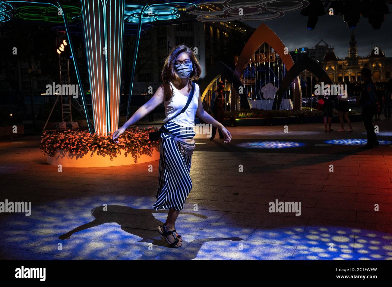 Vietnamese woman dancing solo in the neon lights on Nguyen Hue Walking Street, Ho Chi Minh City, Vietnam Stock Photo