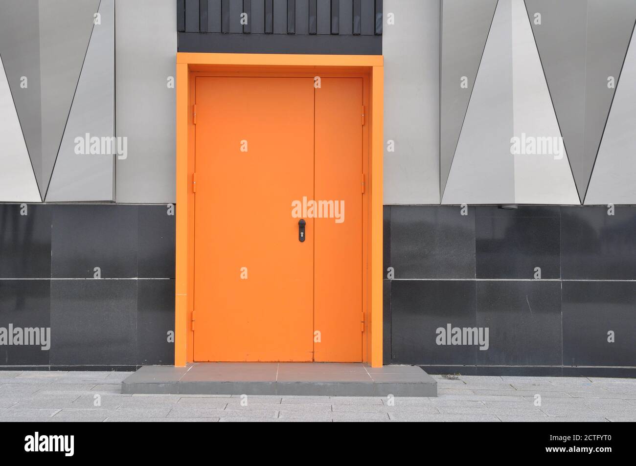 closed metal fire door in orange color. Stock Photo