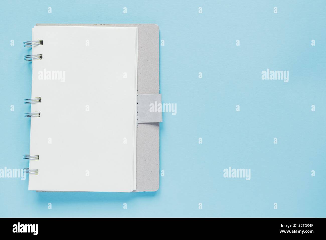 Clean spiral note book for notes and messages on blue background. Minimal business flat lay Stock Photo
