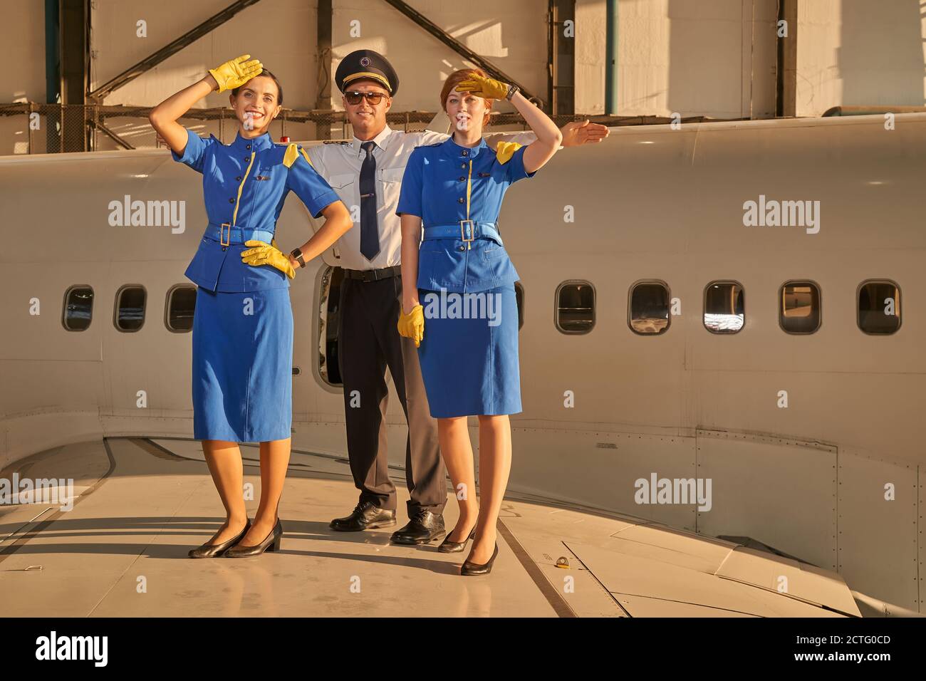 Pretty flight hostesses posing with their coworker Stock Photo