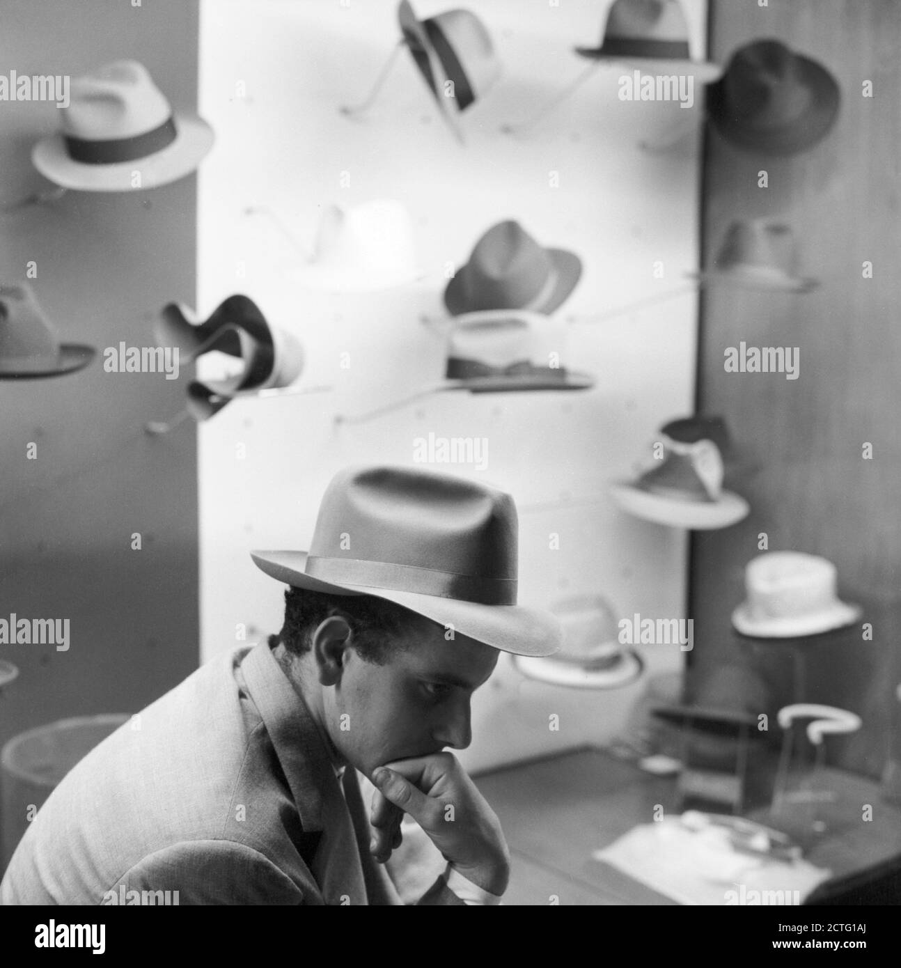 Presentation of the new Borsalino hats. In the photo: a model with a  Borsalino hat; behind him, other hats produced by the company. Alessandria,  6 september 1959 --- 09/06/1959 Presentazione dei nuovi