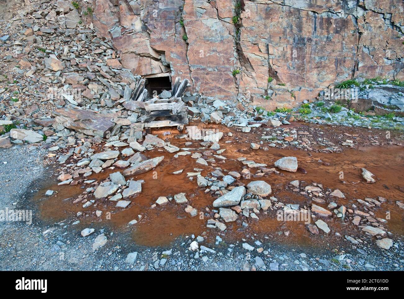 Adit entrance to underground gold mine, rust colored water coming out of tunnel, road to Clear Lake, San Juan Mountains, near Silverton, Colorado, USA Stock Photo