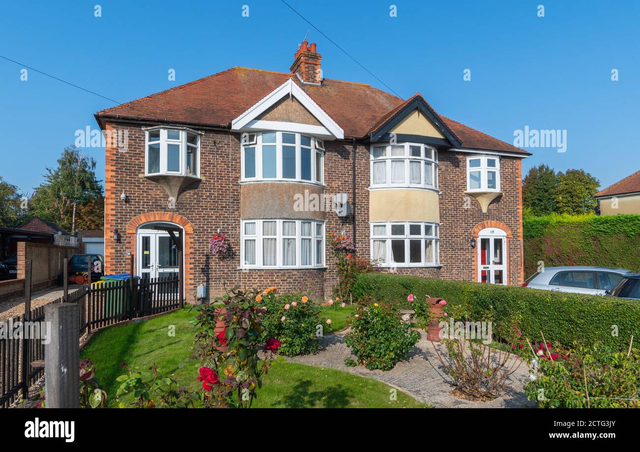 Large 2-storey British 1930s semi-detached houses made of brick with curved bay windows in West Sussex, England, UK. Stock Photo