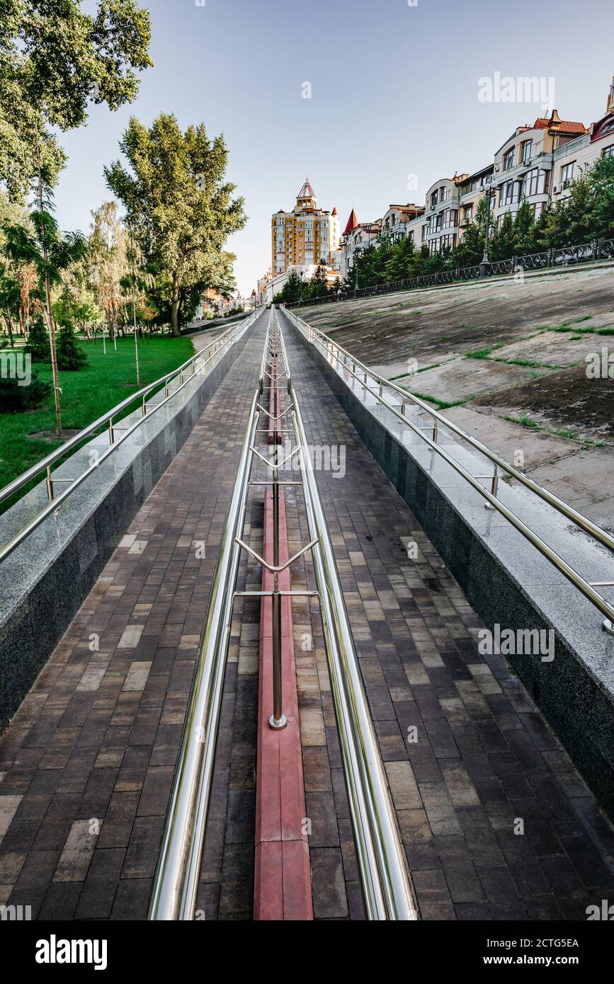 A long metal ramp for handicapped people, bicycles and people with strollers, near Natalka Park in the Obolon district of Kiev, Ukraine. Stock Photo