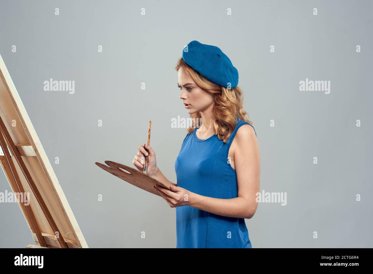 woman artist blue beret palette drawing on easel art creativity light ...