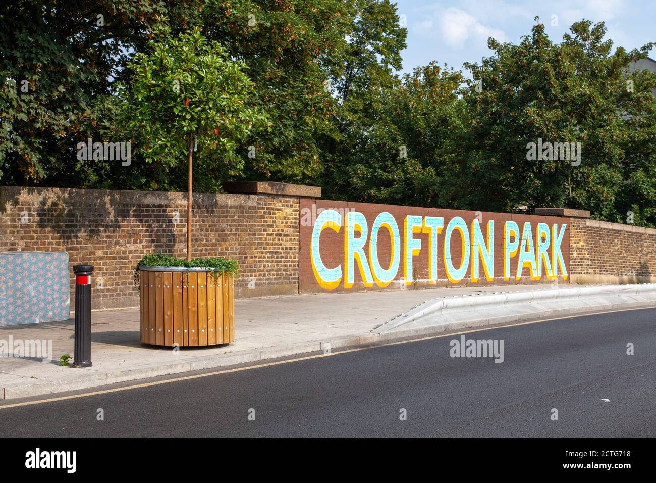 Crofton Park mural and potted Photinia shrub, Lewisham, London Stock Photo