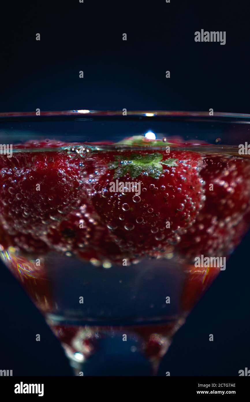 Strawberries fruits in Champagne, transparent glass, background Stock Photo