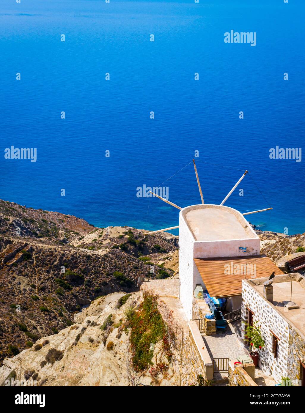 Old White Windmill overlooking Aegean sea in Traditional village of Olympos, Karpathos, Dodecanese Island, Greece Stock Photo