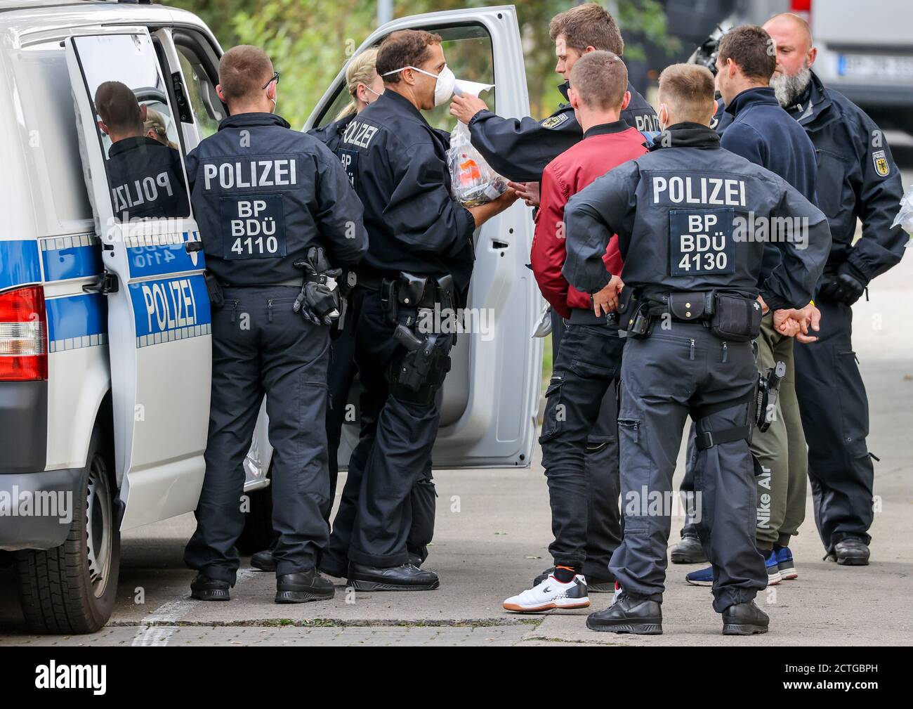 23 September 2020, Saxony-Anhalt, Weißenfels: Two suspects are taken away  by federal police officers after a raid to establish their identities. On  Wednesday, federal police searched more than 60 residential and business
