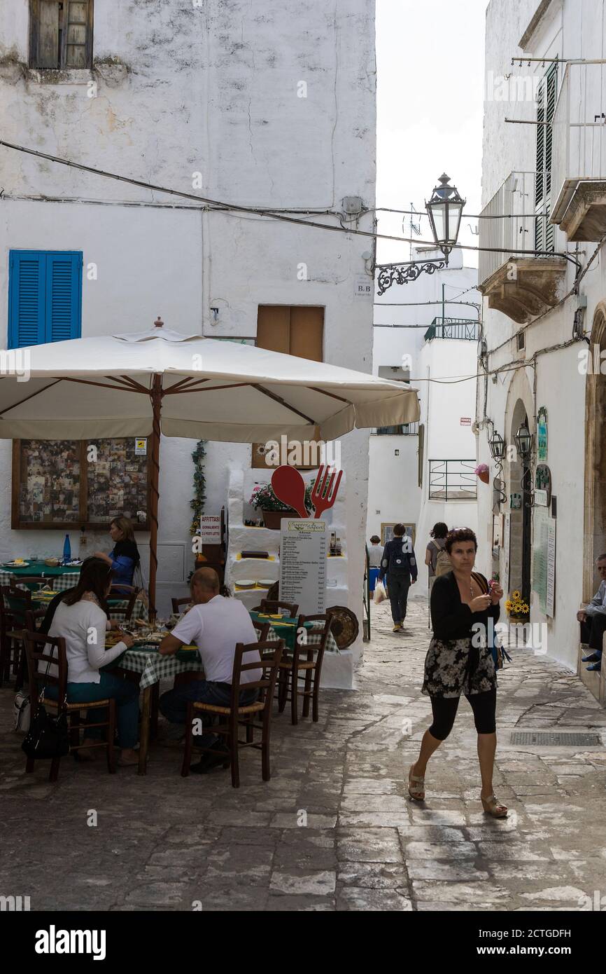 Lunch 'all'aperto' on Vicolo Cantore Incalzi, in the historic old centre of Ostuni, the White Town (La Città Bianca), Apulia, Italy Stock Photo