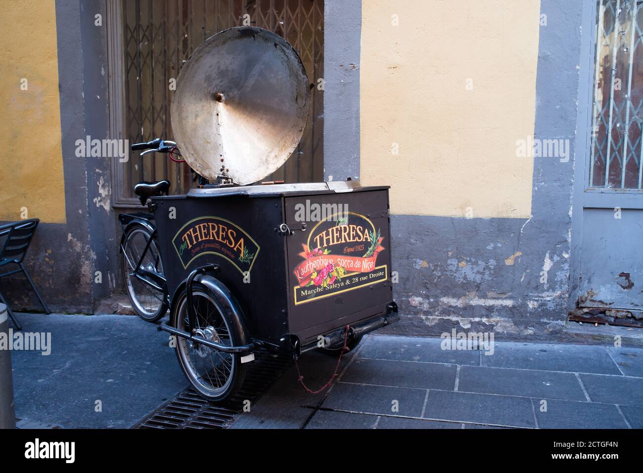Cargo food bike of a 'socca' (local food specialty) merchant in a small old street in Nice during the summer. Stock Photo