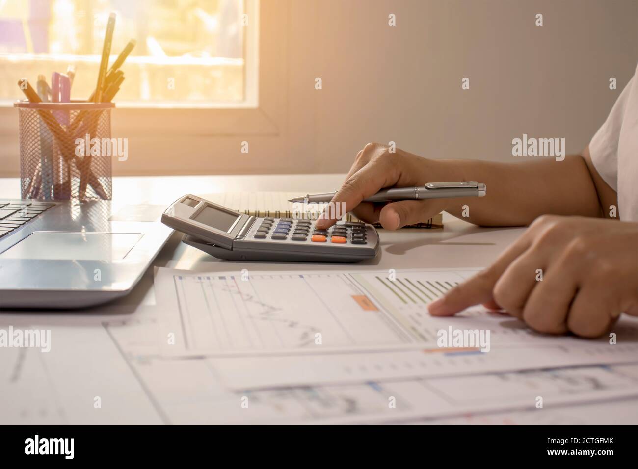 Close-up of businessmen or accountants holding a pen and pressing on the calculator to calculate business information, accounting documents, business Stock Photo