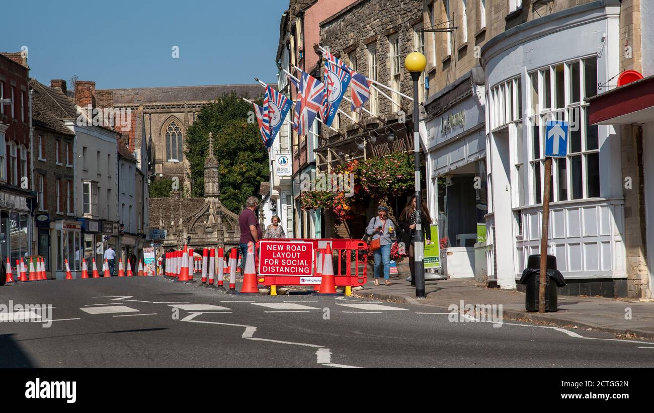 Malmesbury, Wiltshire, England, UK. 2020, Social distancing traffic cones and signage in the main street of this historic market town. Looking towards Stock Photo