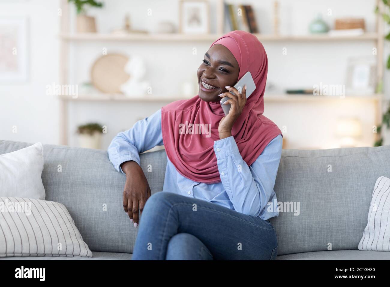 Young black muslim woman in hijab talking on mobile phone at home Stock ...