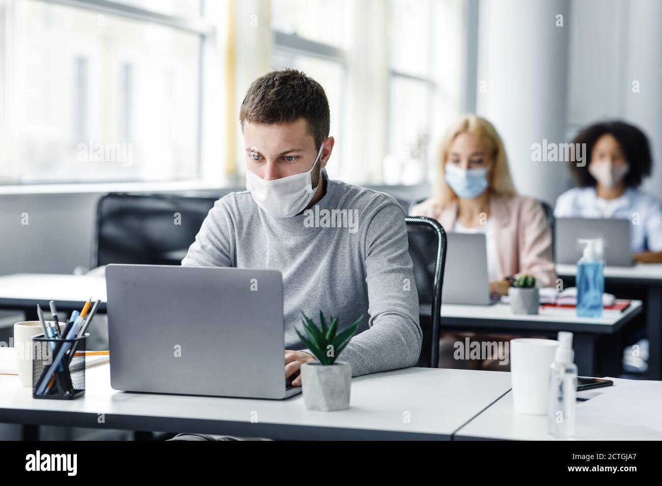 Coworking office and safe work during coronavirus epidemic. Young man ...