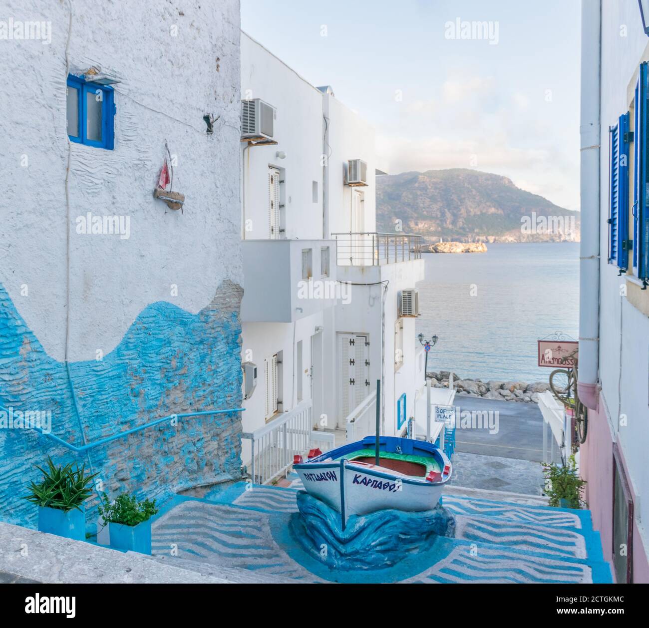 Pigadia, Karpathos, Greece - October 4, 2019: Popular tourist photo spot in Pigadia town with colored stairway alley and boat in the middle, morning Stock Photo