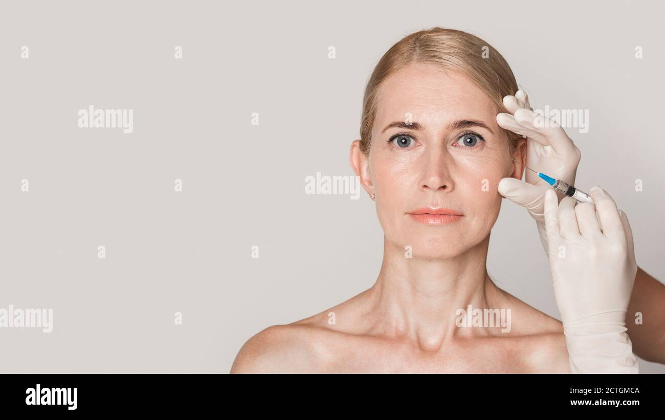 Middle aged woman getting anti aging injection Stock Photo