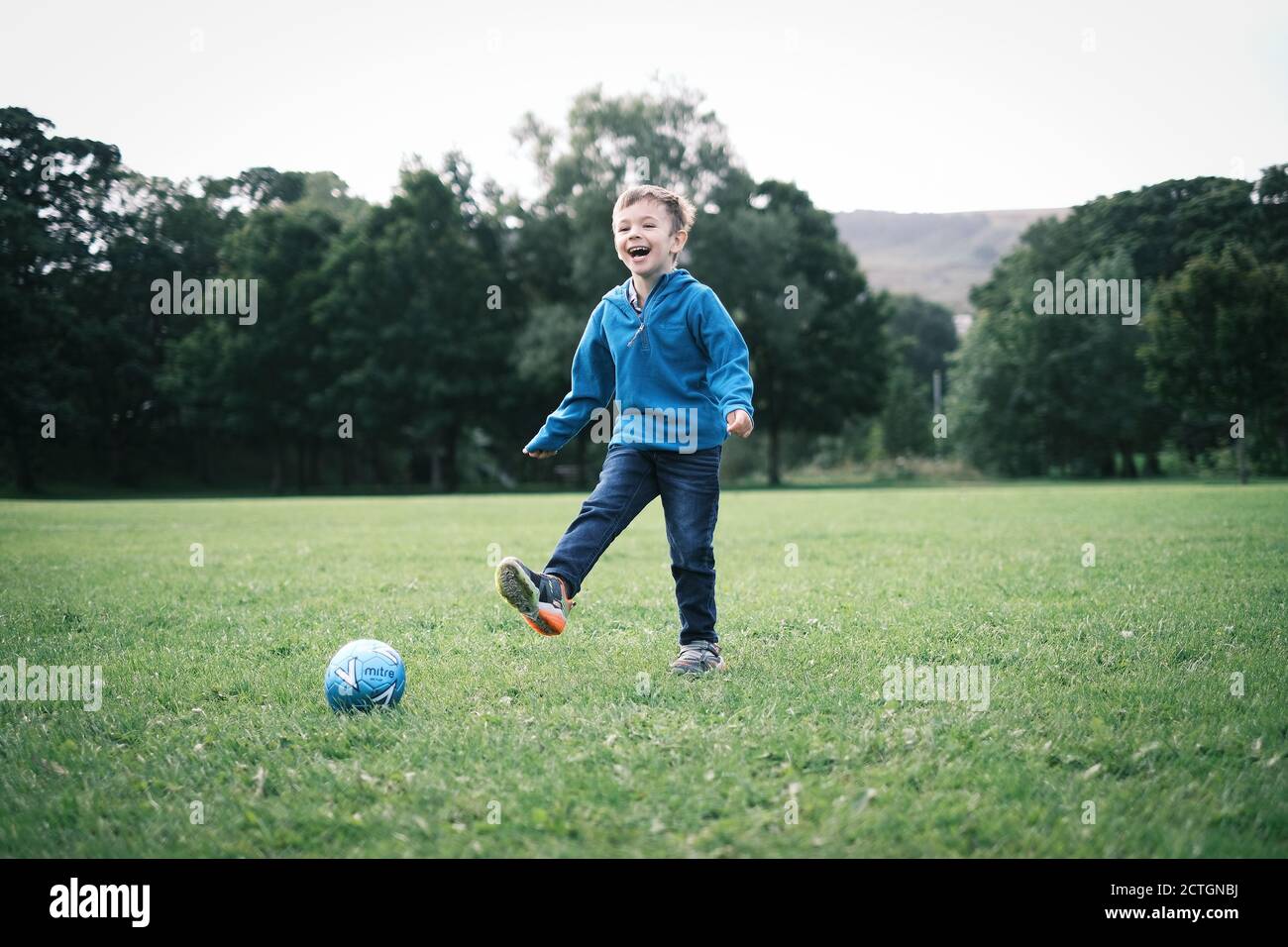 Boy laughing kicking ball hires stock photography and images Alamy