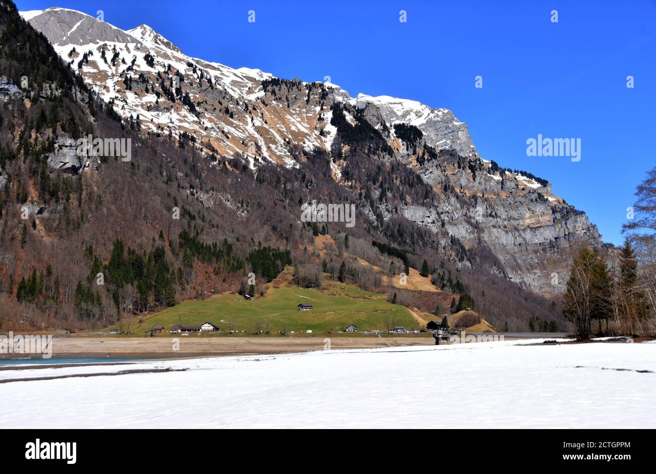 Panorama of Alps from Klontalersee lake in the foreground in early spring sunny day in Klöntal, Schwyz Alps, canton Glarus, Switzerland. Stock Photo