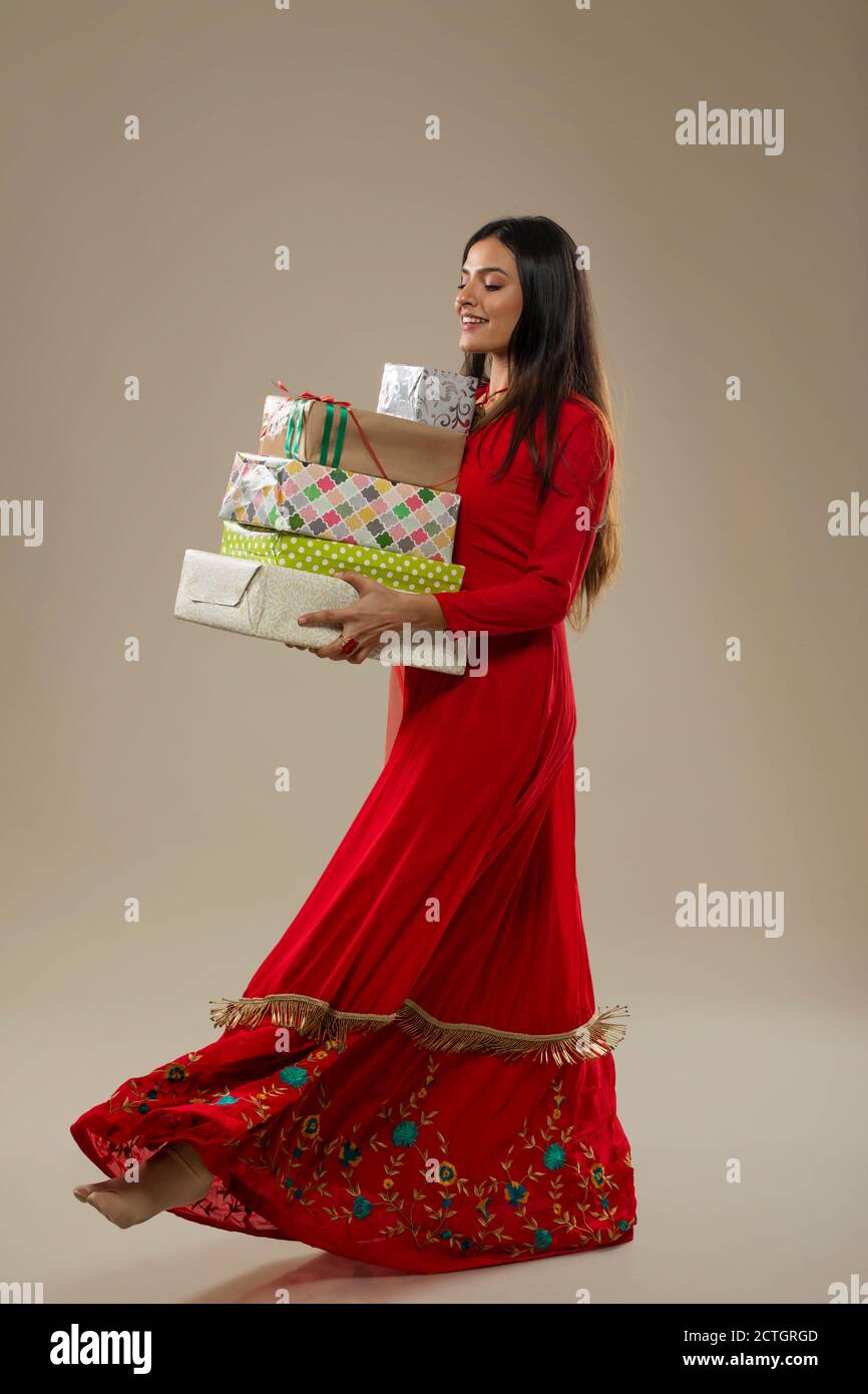 Beautiful woman in ethnic suit holding gift boxes in her hand Stock Photo