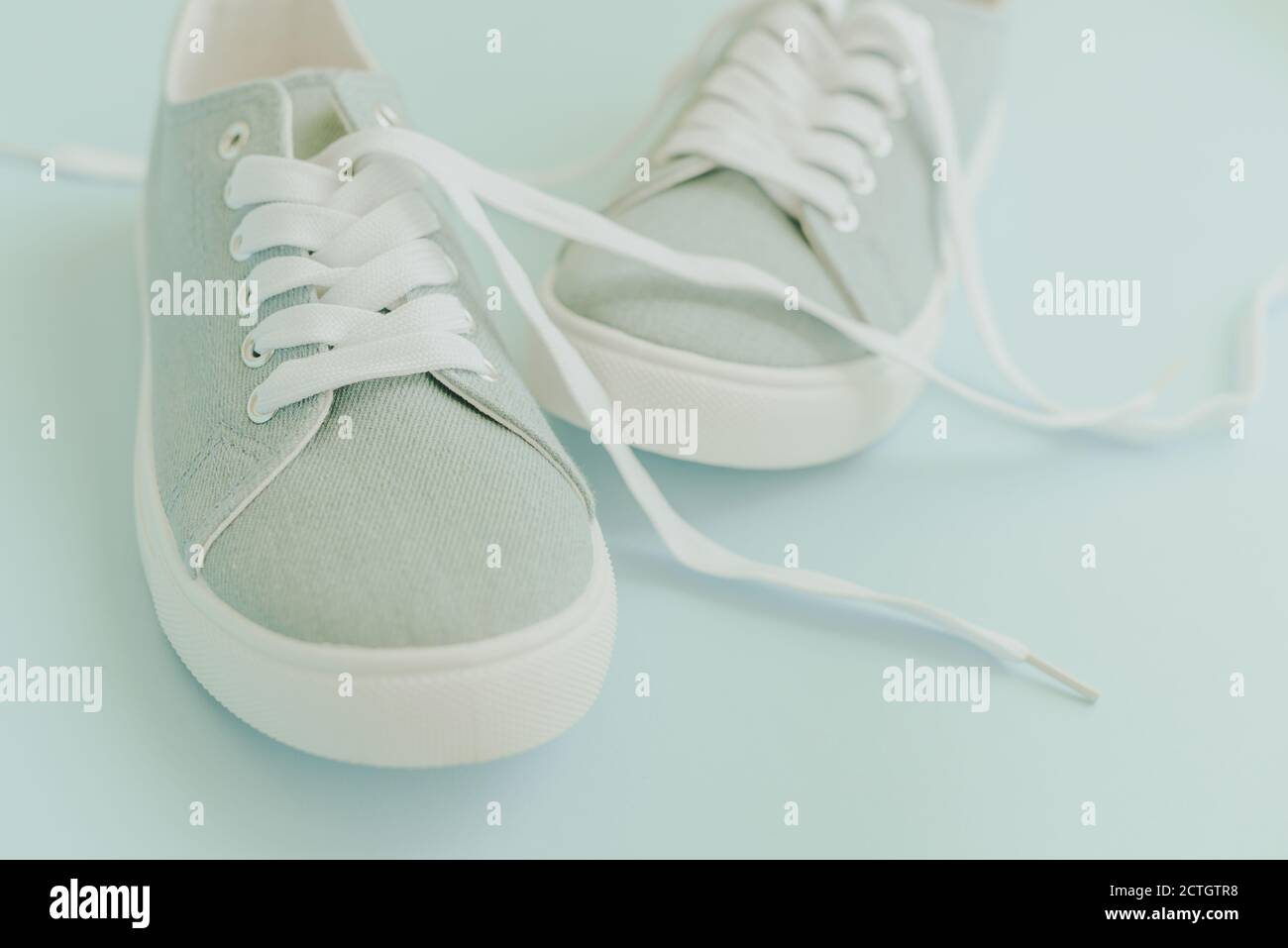 Blue sneakers with white laces on a light blue background. Trendy ...
