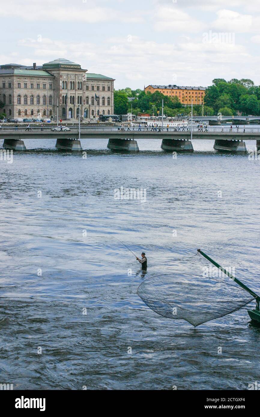 RECREATIONAL FISHING man standing in the water of Stockholm downside Royals palace Stock Photo