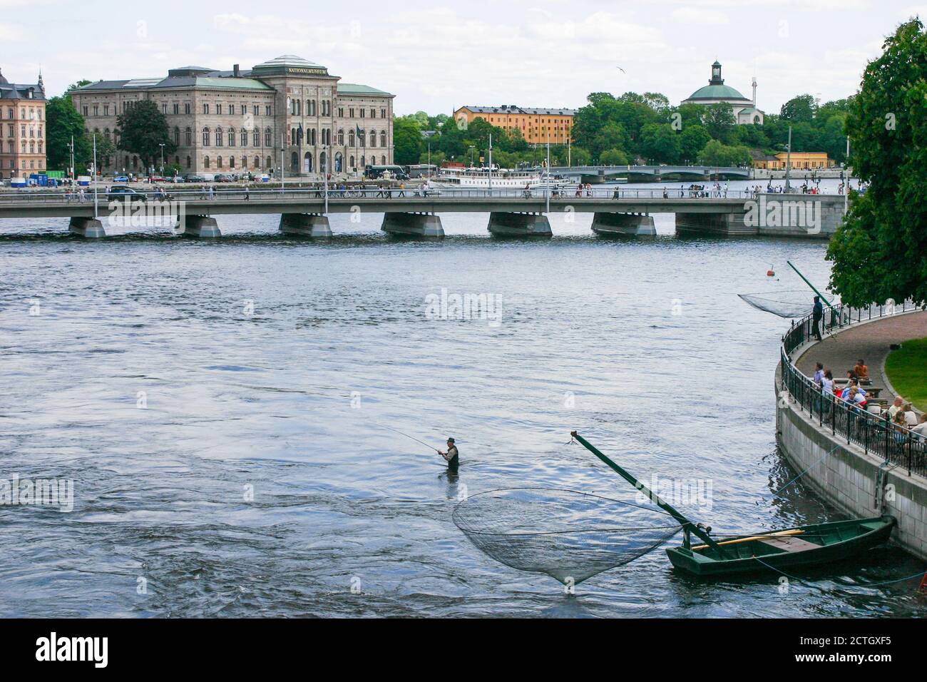 RECREATIONAL FISHING man standing in the water of Stockholm downside Royals palace Stock Photo