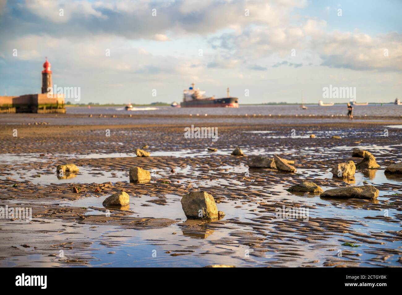 Beach in Bremerhaven at low tide with shipping on the Weser in the background Stock Photo