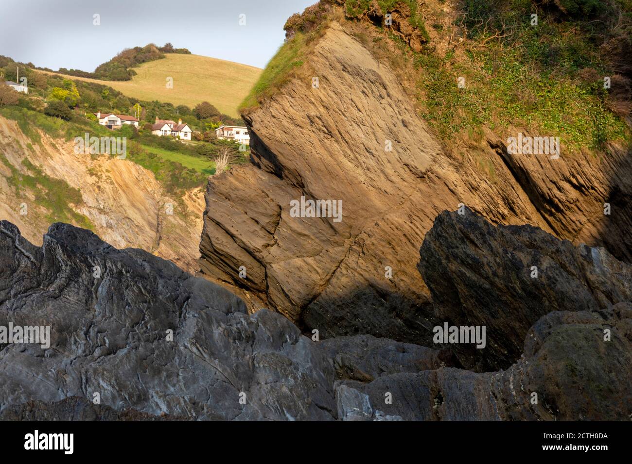 A view of Combe Martin, Devon from a small cove, in the evening sunlight Stock Photo