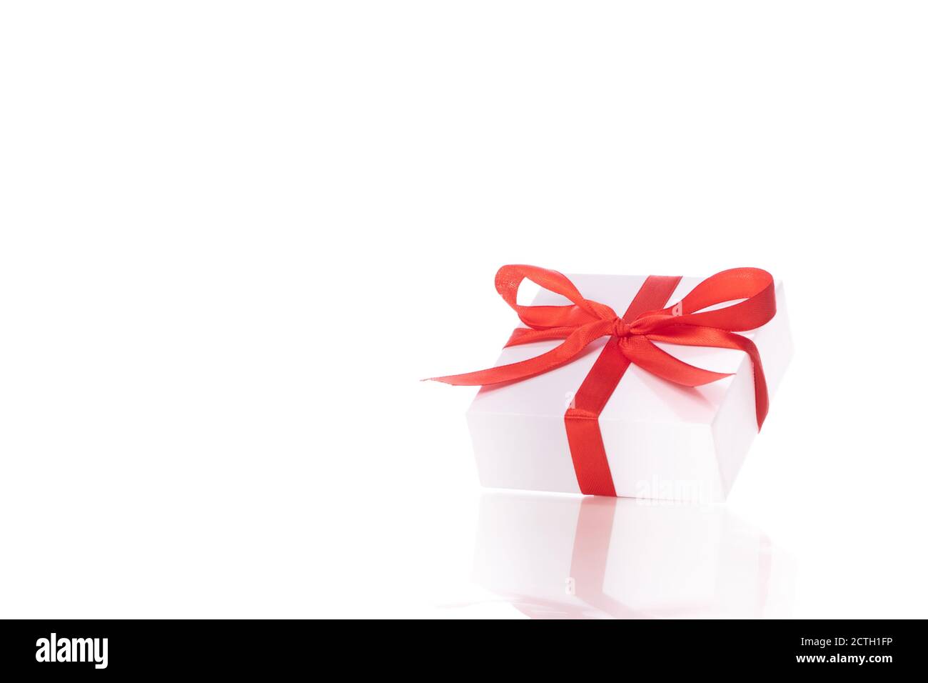 White cardboard gift box tied with red satin ribbon and bow isolated ...
