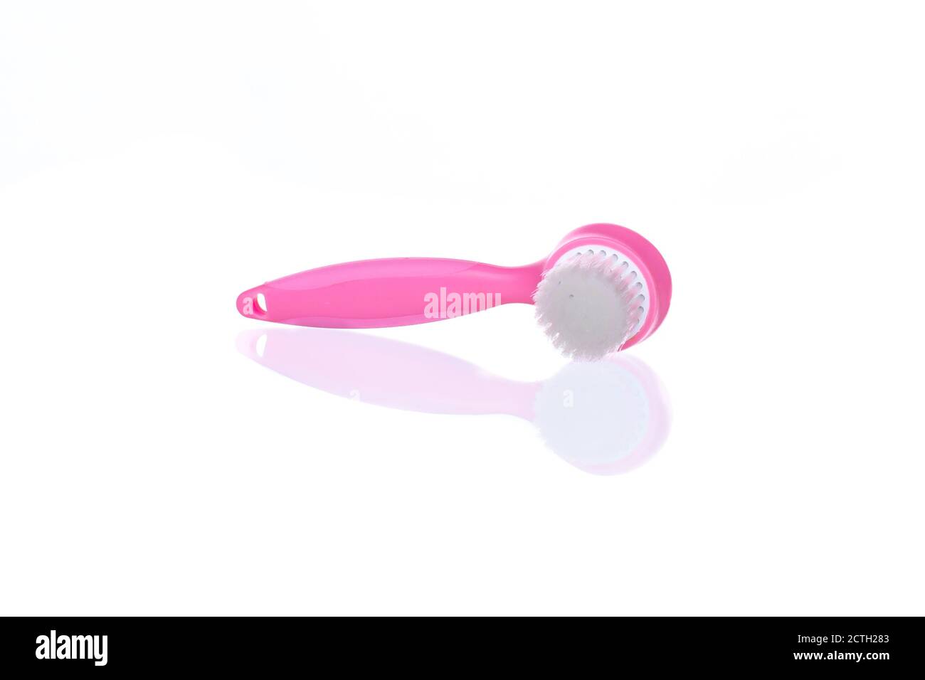 Pink facial cleansing brush on white background image