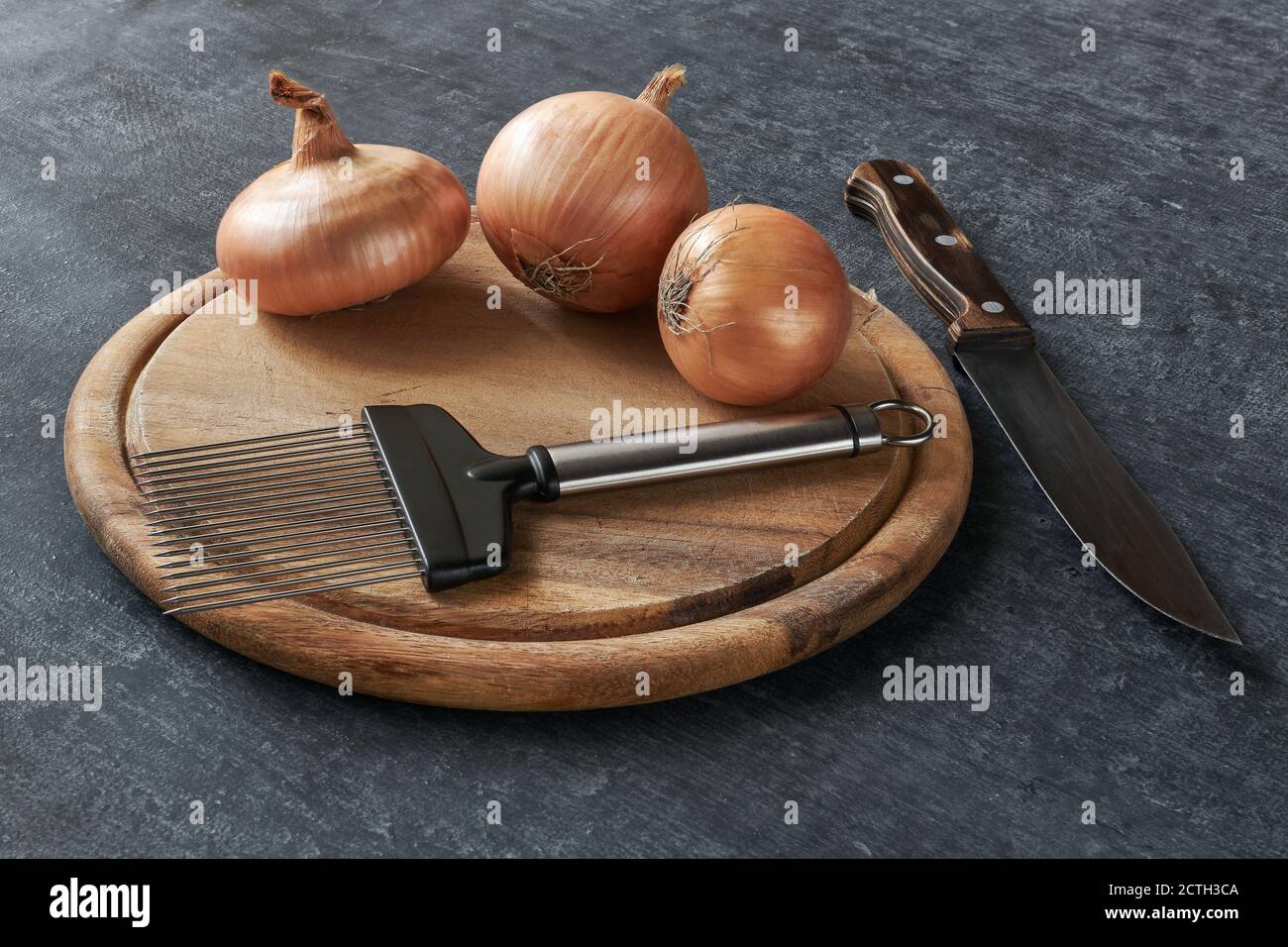 Onion cutting holder on cutting board, three onions and kitchen knife Stock Photo Alamy