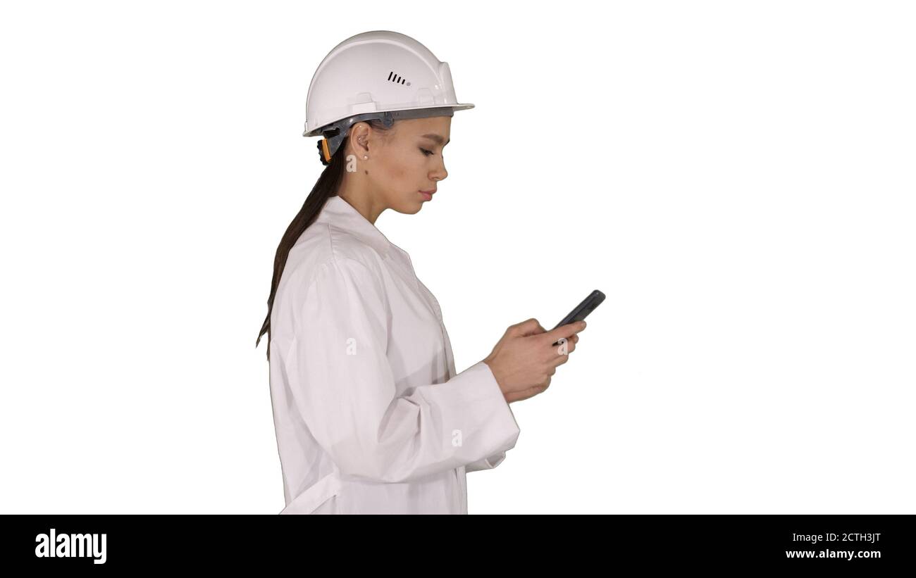 Engineer using mobile phone texting while walking on white backg Stock Photo