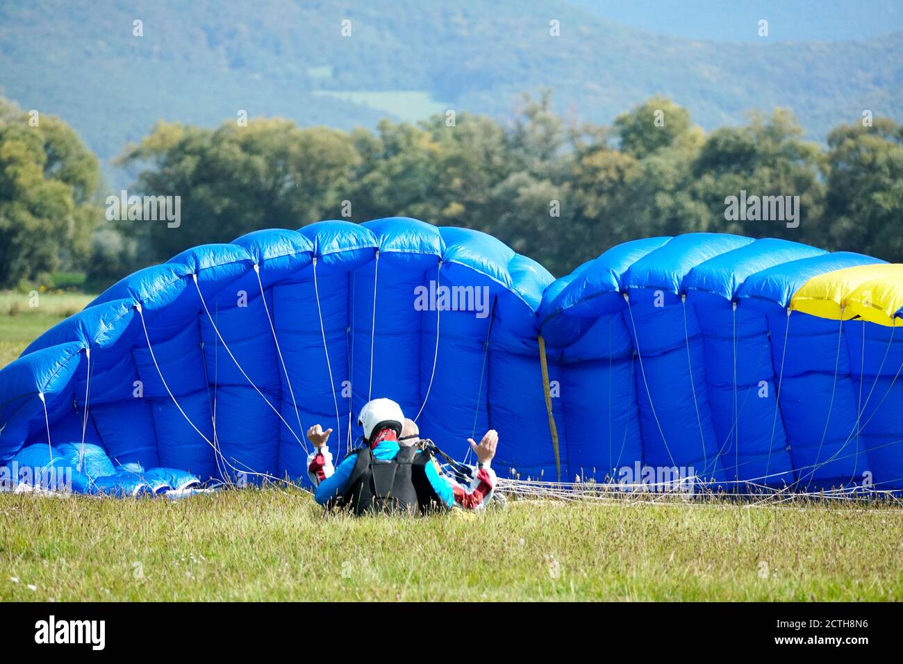 Tandem skydiving landing colourful photography with unrecognisable persons in Slavnica, Slovakia on Sept. 20, 2020. Stock Photo